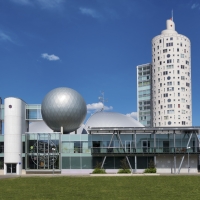 Modern building of science center Ahhaa and apartment skyscraper Tigutorn in Tartu, Estonia. Round facade with windows.